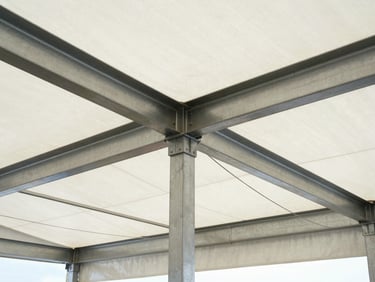 Structural eye-level shot of a heavy-duty industrial warehouse tent frame, massive steel joints, bright natural daylight, high contrast metal textures, sharp focus