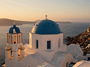 Warm sunset light over whitewashed blue-domed churches in Santorini, Aegean sea in the background