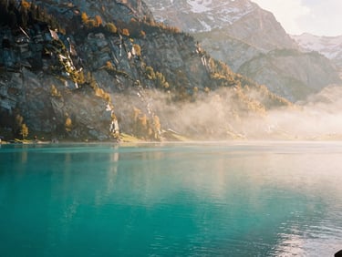 Turquoise glacial waters of Lake Brienz surrounded by towering Swiss Alps under morning mist