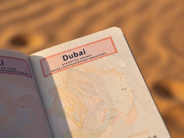 Close-up of a passport with a Dubai entry stamp, held by a hand, warm golden light