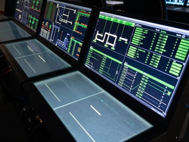 Wide overhead shot of a command-center interface panel displaying live operational pipeline dashboard — multiple data channels active, neon green status indicators, deep black surface with frosted glass card overlays, cinematic high-contrast backlight, hardware cables visible at edge, no people
