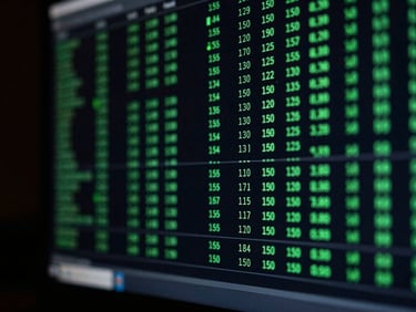 Macro close-up of a dark terminal screen displaying complex trade logs and clean green technical indicators, low-key lighting