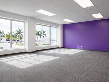 Bright commercial photography of a spacious, empty office suite with clean grey carpets and large windows, bright Florida daylight, 35mm