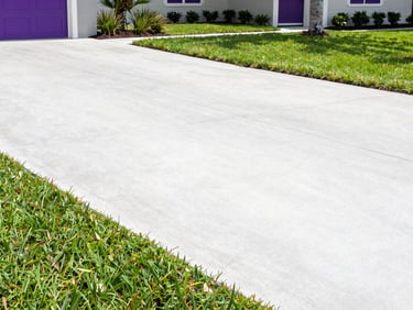 Bright commercial photography of a clean, swept concrete driveway next to a manicured lawn, bright sunny day in Jacksonville, 35mm