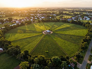 Aerial drone shot of beautifully demarcated premium land plots in New Kasama, lush green surroundings, warm sunset glow
