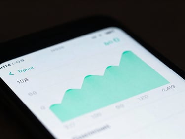 Macro shot of an Android phone screen displaying a clean, dark-mode financial tracking UI with crisp mint green charts, low-key studio lighting, shallow depth of field.