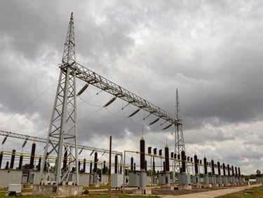 Modern electrical substation against a dramatic overcast sky, low-angle architectural perspective