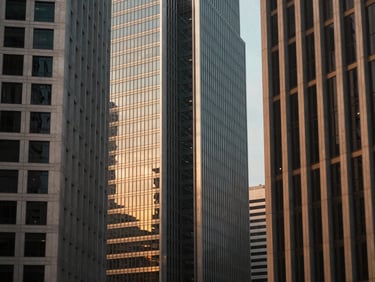 Symmetrical modern skyscrapers of Singapore reflecting warm afternoon light, clean architectural lines, shallow depth of field.