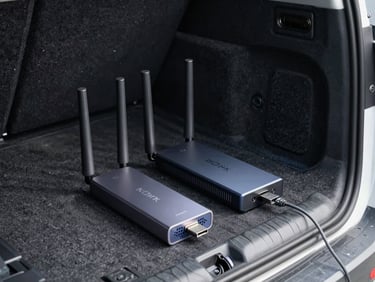 Compact magnetic antenna, travel router, and USB-C power hub arranged on a van cargo floor under natural side-window light, practical layout, no decorative props