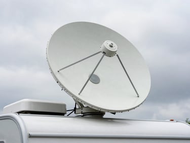 Overhead shot of a Starlink dish mounted flush on an RV roof, rooftop context visible, overcast natural daylight, no glare
