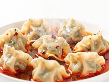 Close-up of Szechuan spicy wontons in red chili oil, steam rising, bright high-key lighting, white background