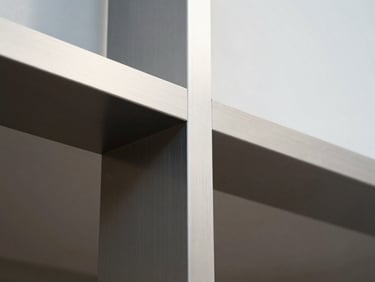 Macro detail of a clean geometric structural form in brushed steel, soft diffused natural light, high-contrast shadows, minimalist architectural photography.