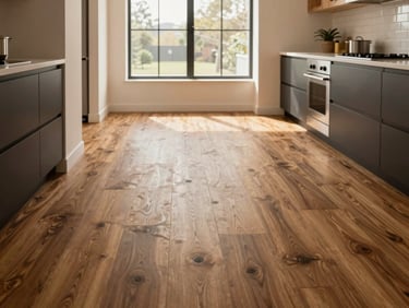 Wide architectural interior shot of a modern kitchen featuring luxury vinyl plank flooring, warm natural window light, clean lines