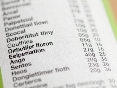 A macro close-up of a food label showing a long list of chemical ingredients, sharp focus, bright daylight