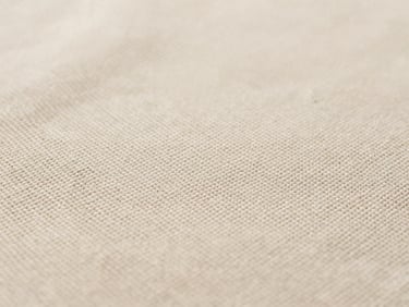 Macro detail of textured beige linen fabric, visible weave structure, soft studio lighting, 35mm photography