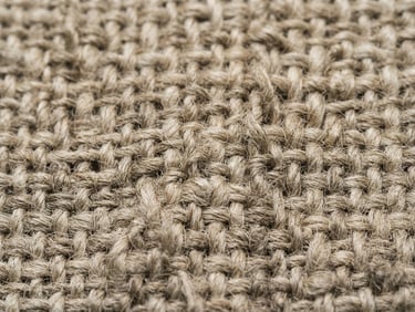 Tactile textile photography, extreme macro detail of raw woven fibers, neutral linen and sand tones, soft diffused studio light, high texture definition, 35mm