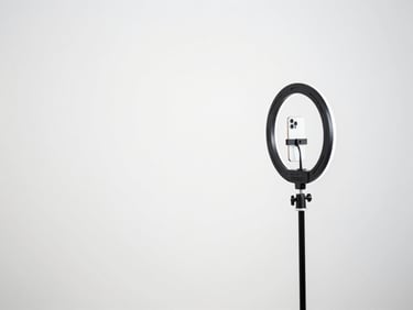 Minimalist UGC video recording setup, smartphone on a ring light, bright white studio background