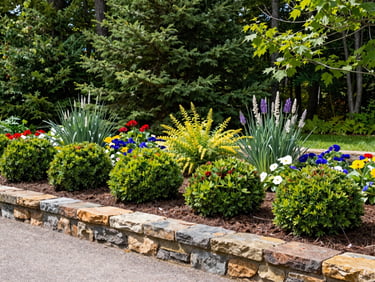 Manicured garden bed with dark mulch, structured shrubs, and vibrant local flowers in Nova Scotia, 35mm