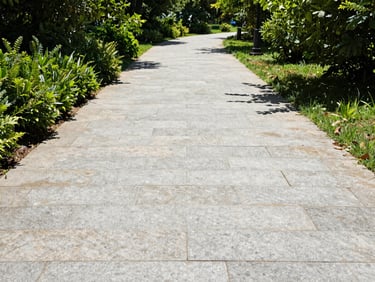 High-contrast before and after of a pressure washed stone walkway, revealing clean light grey stone, 35mm