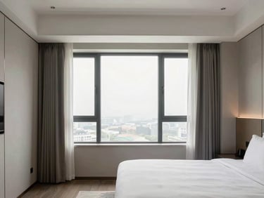 Crisp architectural photography of a completed luxury hotel guestroom with a desaturated color palette and bright window light