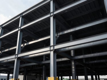 Close-up architectural shot, high-contrast structural lighting, heavy structural steel framing and deep-foundation engineering of a logistics hub.