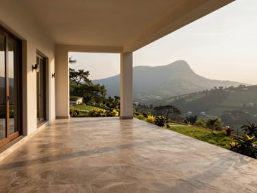 Sun-dappled veranda of a luxury estate in Karjat, looking out towards the Western Ghats, soft golden hour lighting, clean architectural lines and natural stone flooring.