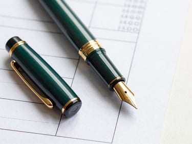 Macro shot of a high-end fountain pen resting on structured financial ledger documents, clean daylight, deep green and gold tones, editorial corporate photography