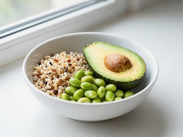 Bright editorial flat-lay of a vibrant green avocado and edamame grain bowl, clean white ceramic bowl, natural window light