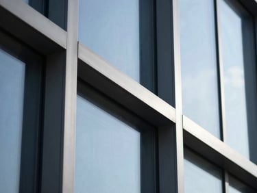 Extreme close-up of minimalist steel and glass architectural lines, sharp shadows, cool blue tones