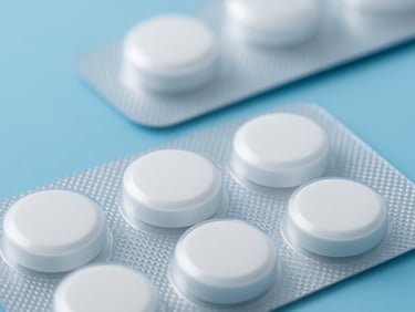 Macro shot of pharmaceutical blister packs with white tablets, clinical blue background, clean lighting