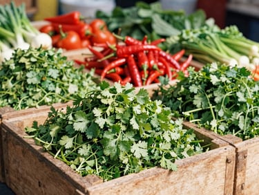 Vibrant piles of fresh green coriander, bright red chillies, and seasonal vegetables in rustic wooden crates, bright daylight, 35mm