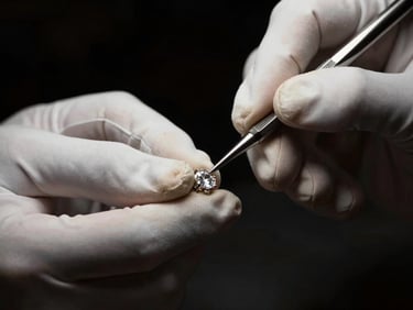 Close-up of a master jeweler's hands, wearing white gloves, using fine tools to polish a diamond setting, dramatic side lighting, deep black and champagne tones, high contrast, luxury editorial, 85mm