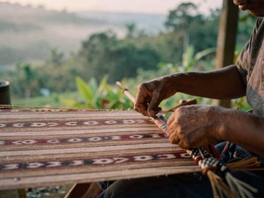 Close up of artisan hands weaving traditional ikat fabric in a misty Flores highland village, soft natural light, editorial photography
