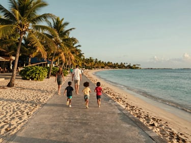 Wide shot of a family walking along a quiet beach promenade in Punta Cana Dominican Republic at golden hour, children running ahead on the sand, parents strolling behind, calm turquoise sea to one side, palm trees lining the path