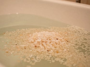 Tight macro shot of a deep-soaking bathtub filled with warm water, premium bath salts, soft ambient glow