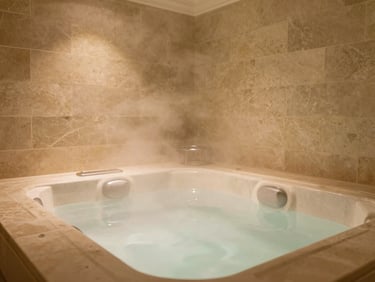 Close-up of a private in-room jacuzzi with soft rising steam, warm low-key indoor lighting, elegant stone tiling