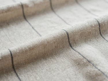 Macro close-up of heavy linen weave, soft cream and charcoal tones, shallow depth of field