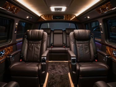 Luxury executive lounge interior of a customized coach, plush leather captain chairs, polished wood and chrome accents, ambient warm light.