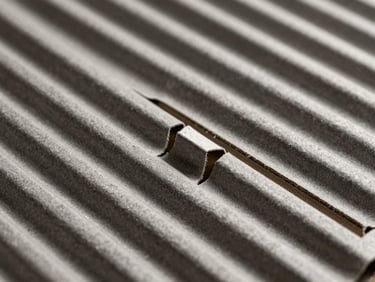 Macro shot of raw corrugated paper fluting, high-contrast technical studio lighting, sharp shadows defining the interlocking cardboard tabs, charcoal and kraft tones.