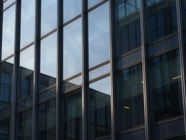 Macro details of modern glass office facade with sharp geometric shadows, cool morning light, deep navy and steel tones, 35mm