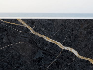 Extreme close-up of premium dark marble texture with gold veins, soft natural lighting, high-end editorial feel