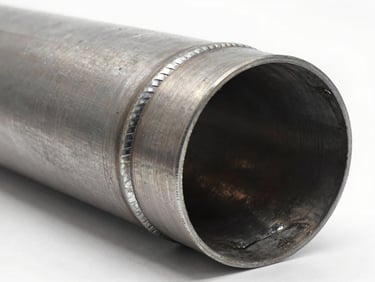 Heavy industrial steel pipe bend with a welded outer reinforcement back-channel, rugged weld seams, crisp studio lighting