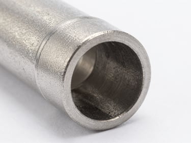 Macro close-up of a steel pipe elbow with a spherical vortex chamber, technical cutaway showing interior flow path, studio lighting