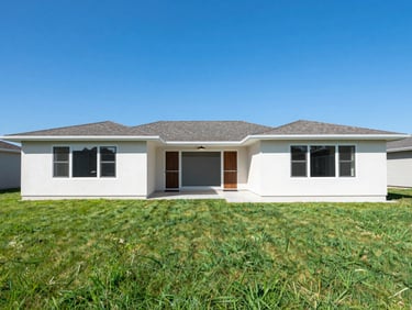 Real estate exterior with vibrant blue sky replacement and lush green grass enhancement, balanced daylight, wide-angle lens, natural saturated tones
