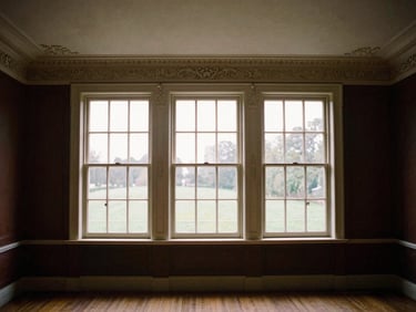 Symmetrical wide-angle shot of a restored Victorian parlor, natural window light illuminating hand-carved crown molding and pristine plasterwork.
