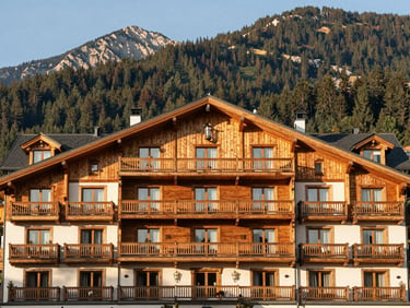 Luxury hotel facade in Zakopane, traditional wooden design elements, mountain backdrop