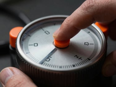 Close-up of a hand operating a physical industrial timer, high-contrast, dramatic shadows, safety orange details, extreme close-up.