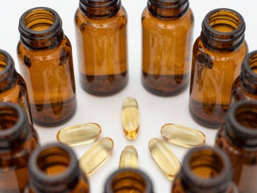 Macro shot of amber glass bottles containing golden softgel capsules, arranged in a precise geometric grid under clinical white light.
