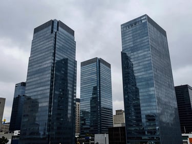 Wide panoramic shot of modern glass office towers in Bogotá financial district, cool overcast daylight, desaturated blue tones, 35mm