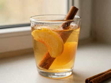 A glass of vibrant peach tea with fresh peach slices and a cinnamon stick, condensation on the glass, warm golden light, shallow depth of field